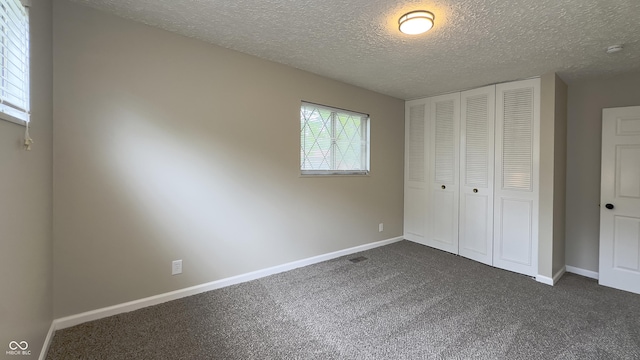 3019 E Berwyn St, Indianapolis, IN 46203 - unfurnished bedroom with dark carpet, a closet, and a textured ceiling