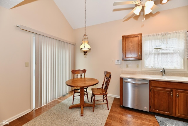 6965 Steinmeier Dr W, Indianapolis, IN 46220 - kitchen with dishwasher, lofted ceiling, light countertops, brown cabinetry, and a ceiling fan