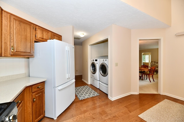 6965 Steinmeier Dr W, Indianapolis, IN 46220 - kitchen with separate washer and dryer, freestanding refrigerator, brown cabinetry, and light countertops