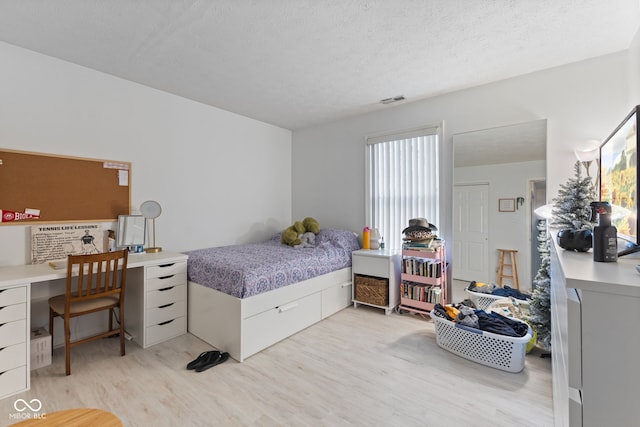 8038 Midlothian Way, Indianapolis, IN 46214 - bedroom featuring light wood-type flooring, a textured ceiling, and an office area