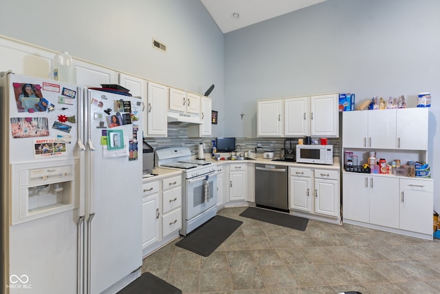 8038 Midlothian Way, Indianapolis, IN 46214 - kitchen featuring white appliances, high vaulted ceiling, under cabinet range hood, white cabinets, and backsplash