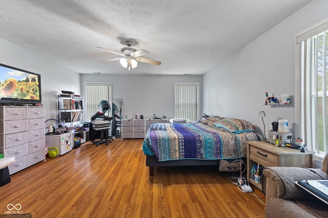 8038 Midlothian Way, Indianapolis, IN 46214 - bedroom with light wood-type flooring, a textured ceiling, ceiling fan, and a desk