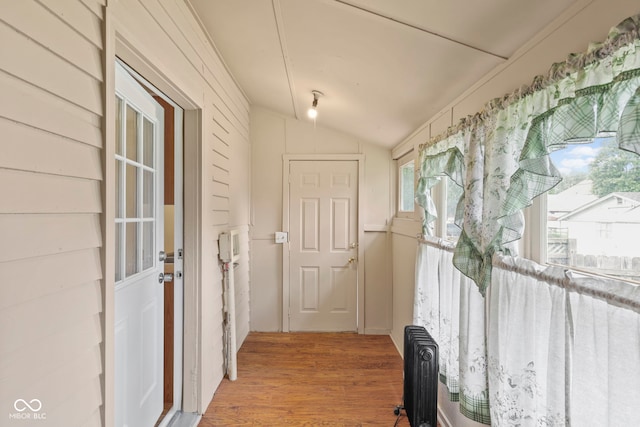 113 N Munsie St, Indianapolis, IN 46229 - hall with radiator heating unit, vaulted ceiling, and light wood-style flooring