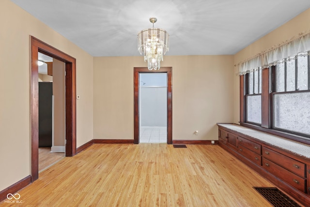 113 N Munsie St, Indianapolis, IN 46229 - empty room with light wood finished floors and a chandelier