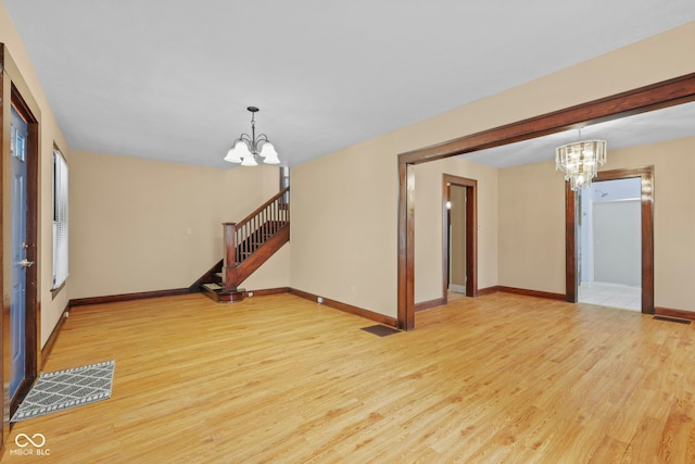 113 N Munsie St, Indianapolis, IN 46229 - empty room featuring a chandelier, light wood-type flooring, and stairs