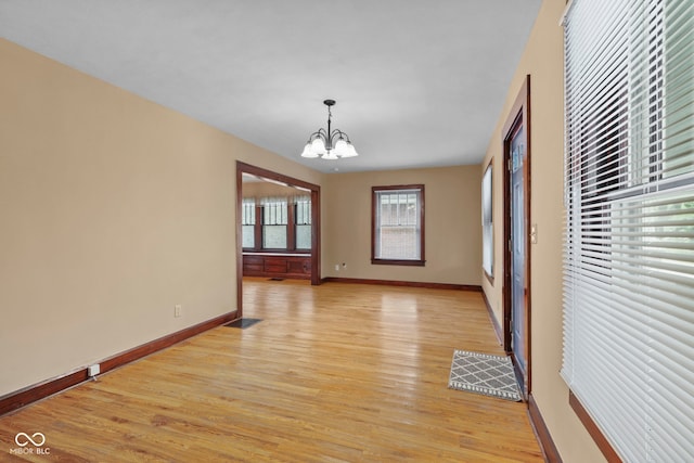 113 N Munsie St, Indianapolis, IN 46229 - unfurnished dining area featuring a chandelier and light wood-style flooring
