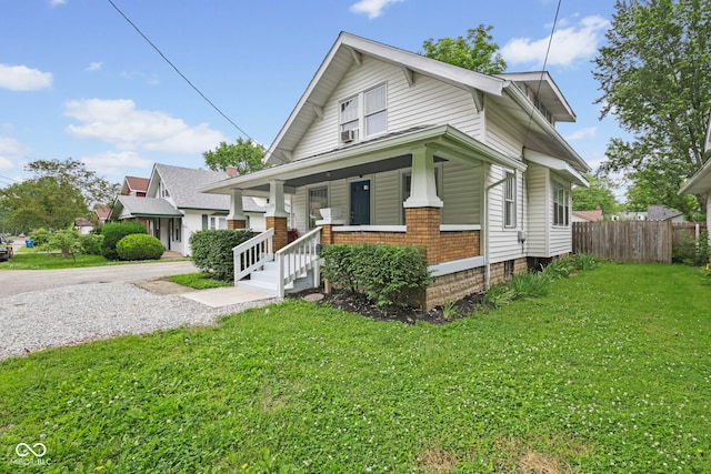 113 N Munsie St, Indianapolis, IN 46229 - bungalow-style home with covered porch, gravel driveway, and cooling unit