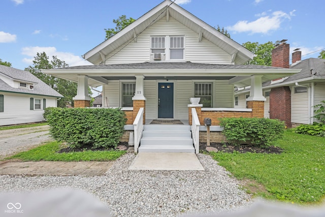 113 N Munsie St, Indianapolis, IN 46229 - view of front of property with a porch, a shingled roof, cooling unit, and brick siding