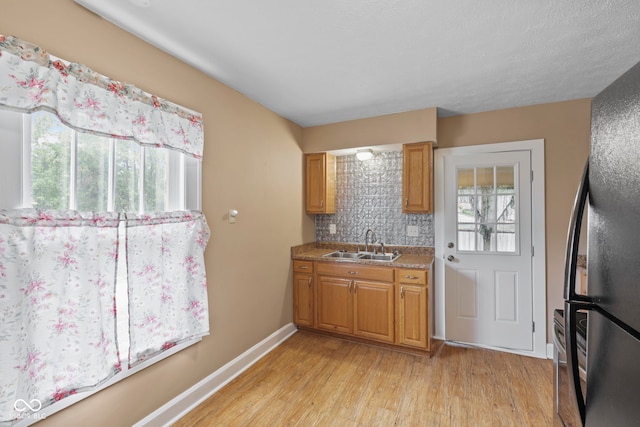 113 N Munsie St, Indianapolis, IN 46229 - kitchen featuring freestanding refrigerator, plenty of natural light, light wood-type flooring, and tasteful backsplash