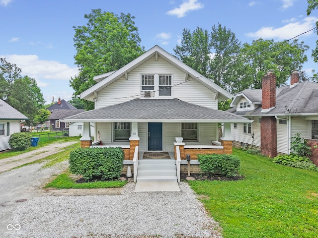 113 N Munsie St, Indianapolis, IN 46229 - view of front of home featuring covered porch, a front yard, a shingled roof, and gravel driveway