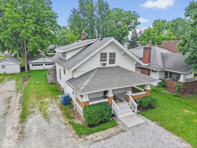 113 N Munsie St, Indianapolis, IN 46229 - view of front of house with a chimney, a front lawn, a shingled roof, a porch, and dirt driveway