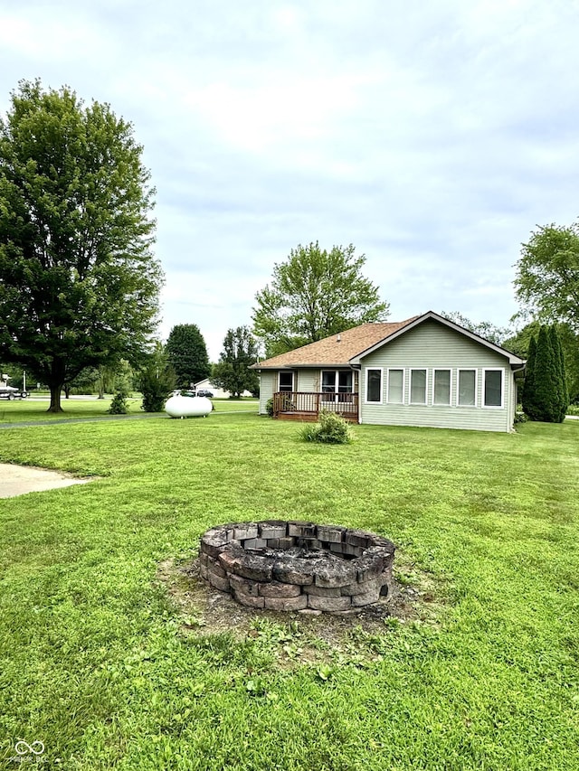 526 Jefferson Vly, Coatesville, IN 46121 - view of green lawn with an outdoor fire pit and a wooden deck