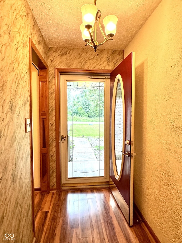 526 Jefferson Vly, Coatesville, IN 46121 - doorway to outside with a chandelier, a textured wall, wood finished floors, and a textured ceiling