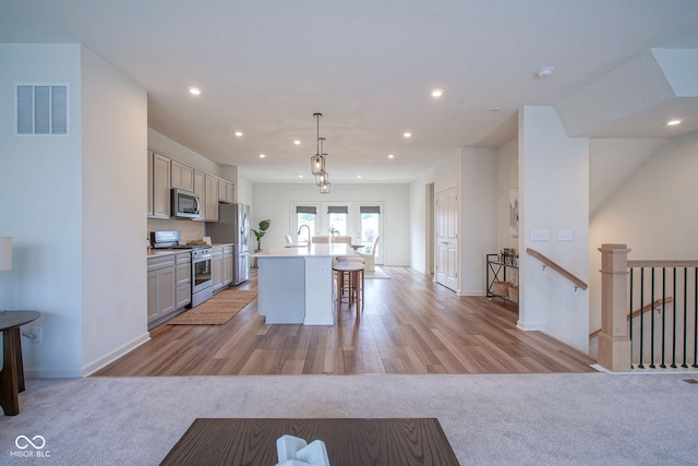9728 Junction, Fishers, IN 46037 - kitchen featuring stainless steel appliances, an island with sink, recessed lighting, a kitchen bar, and light countertops