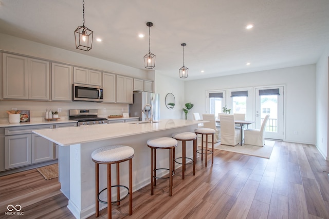 9728 Junction, Fishers, IN 46037 - kitchen featuring stainless steel appliances, gray cabinetry, an island with sink, a breakfast bar area, and recessed lighting