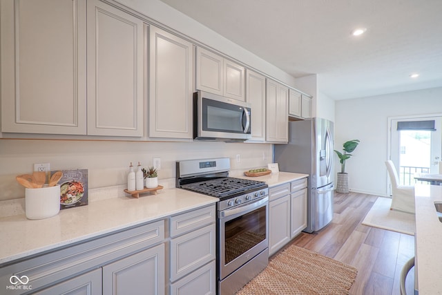 9728 Junction, Fishers, IN 46037 - kitchen featuring stainless steel appliances, recessed lighting, light wood-type flooring, light countertops, and gray cabinetry