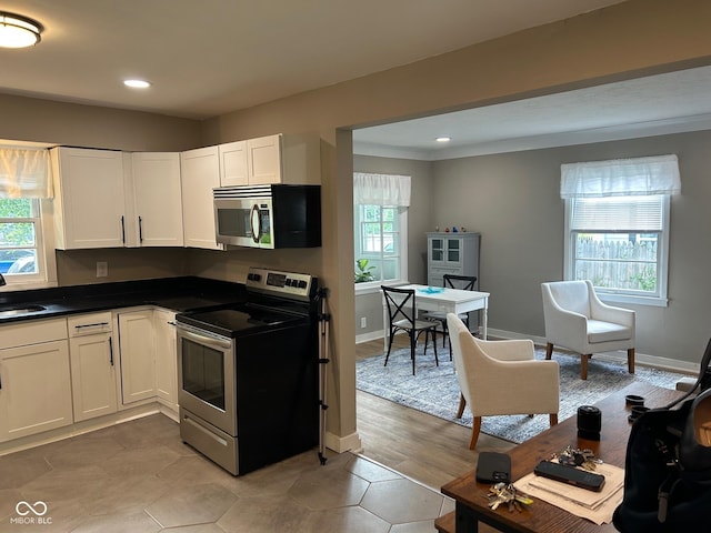 4445 Kingsley Dr, Indianapolis, IN 46205 - kitchen featuring stainless steel appliances, dark countertops, white cabinets, and recessed lighting
