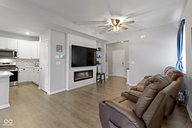 2733 Lamar Dr, Whitestown, IN 46075 - living room featuring ceiling fan, light wood-style floors, a fireplace, and recessed lighting