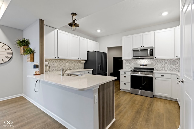 2733 Lamar Dr, Whitestown, IN 46075 - kitchen featuring stainless steel appliances, tasteful backsplash, a peninsula, light wood-style floors, and white cabinetry