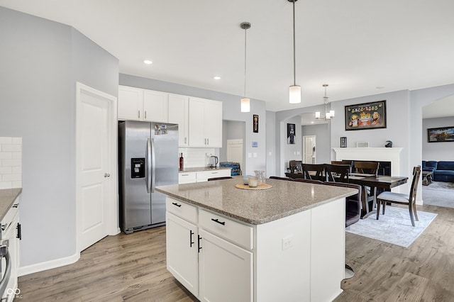 5812 Flat Hill Dr, Indianapolis, IN 46239 - kitchen featuring stainless steel refrigerator with ice dispenser, arched walkways, light wood-style flooring, and recessed lighting