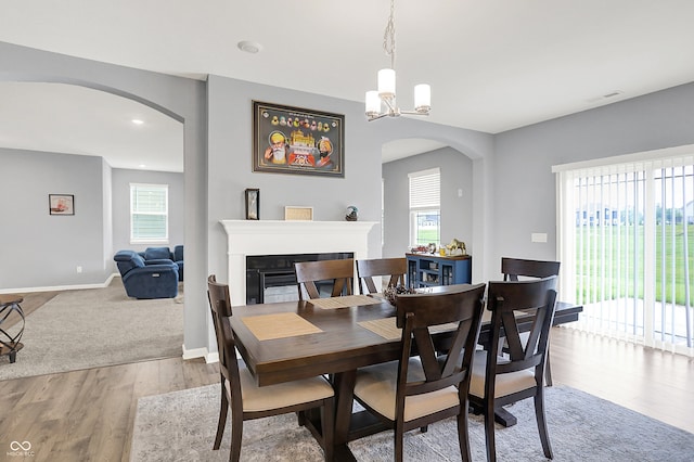 5812 Flat Hill Dr, Indianapolis, IN 46239 - dining space featuring arched walkways, a fireplace, wood finished floors, and a chandelier
