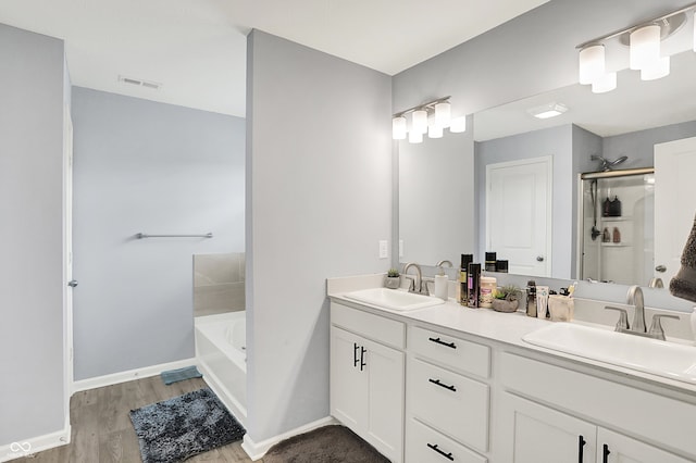 5812 Flat Hill Dr, Indianapolis, IN 46239 - full bathroom with double vanity, a garden tub, wood finished floors, and a stall shower