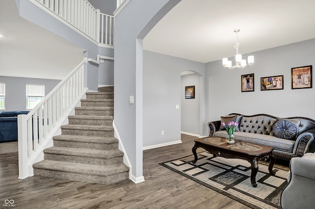 5812 Flat Hill Dr, Indianapolis, IN 46239 - living room featuring arched walkways, stairs, wood finished floors, and a chandelier