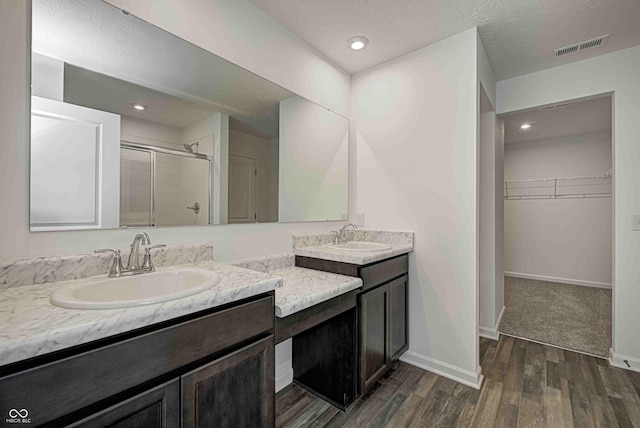 7501 Firecrest Ln, Camby, IN 46113 - full bath featuring double vanity, a walk in closet, a shower stall, wood finished floors, and recessed lighting