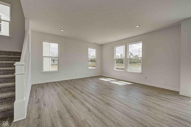 7501 Firecrest Ln, Camby, IN 46113 - unfurnished living room featuring wood finished floors, stairway, a textured ceiling, and recessed lighting
