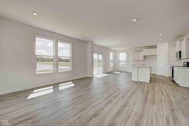 7501 Firecrest Ln, Camby, IN 46113 - unfurnished living room with light wood-type flooring, recessed lighting, and a textured ceiling