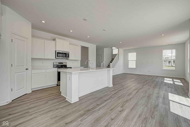 7501 Firecrest Ln, Camby, IN 46113 - kitchen with stainless steel appliances, open floor plan, light wood-type flooring, recessed lighting, and white cabinets