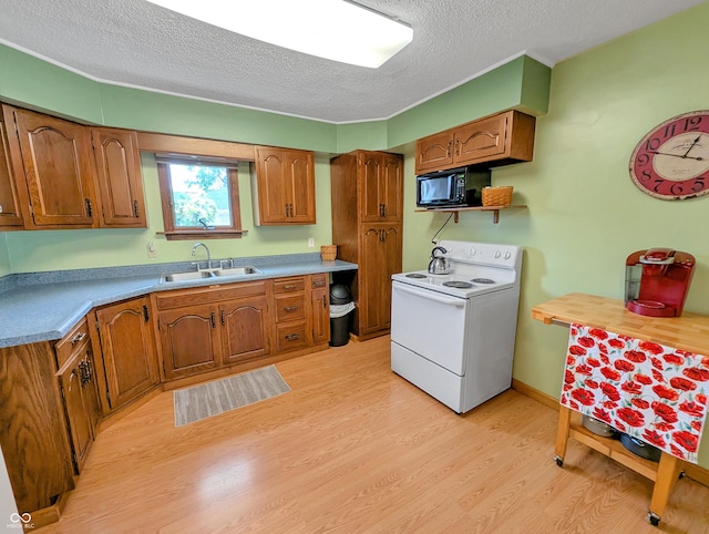 308 W Jefferson St, Kirklin, IN 46050 - kitchen with white range with electric cooktop, black microwave, a textured ceiling, brown cabinetry, and light wood-type flooring