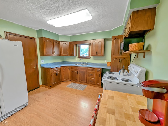 308 W Jefferson St, Kirklin, IN 46050 - kitchen with white appliances, a textured ceiling, brown cabinets, light wood-style flooring, and light countertops