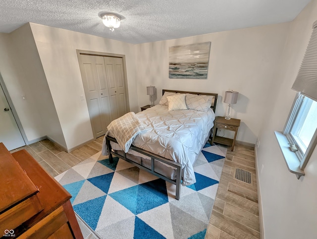 308 W Jefferson St, Kirklin, IN 46050 - bedroom featuring light wood-style flooring, a closet, and a textured ceiling