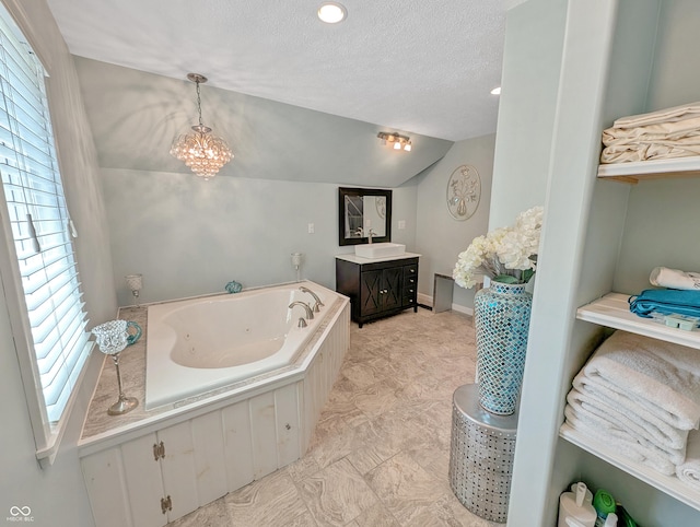 308 W Jefferson St, Kirklin, IN 46050 - full bath with vanity, a tub with jets, a textured ceiling, vaulted ceiling, and a chandelier