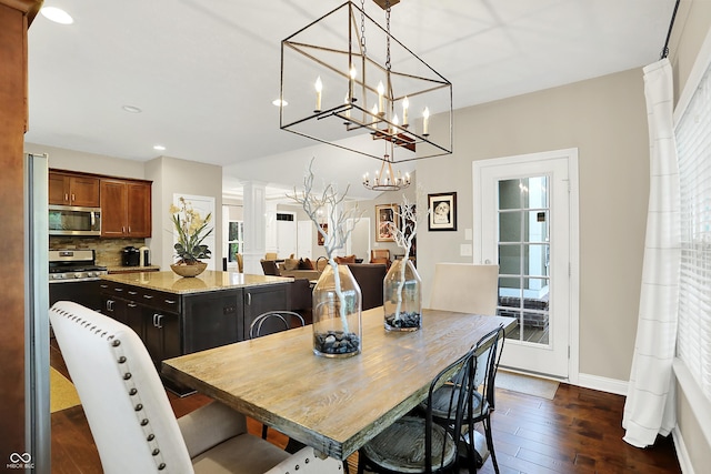 15410 Mission Hills Dr, Carmel, IN 46033 - dining space with decorative columns, recessed lighting, dark wood-style floors, and a chandelier