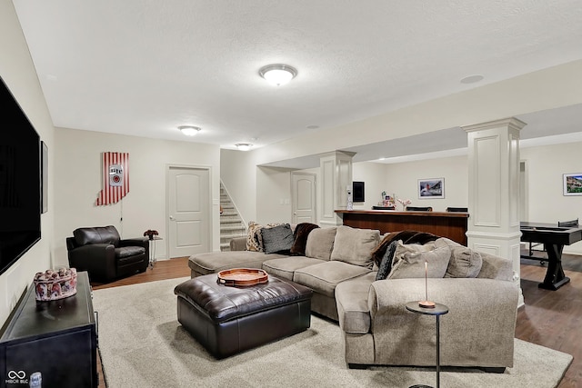 15410 Mission Hills Dr, Carmel, IN 46033 - living area featuring ornate columns, stairs, wood finished floors, and a textured ceiling