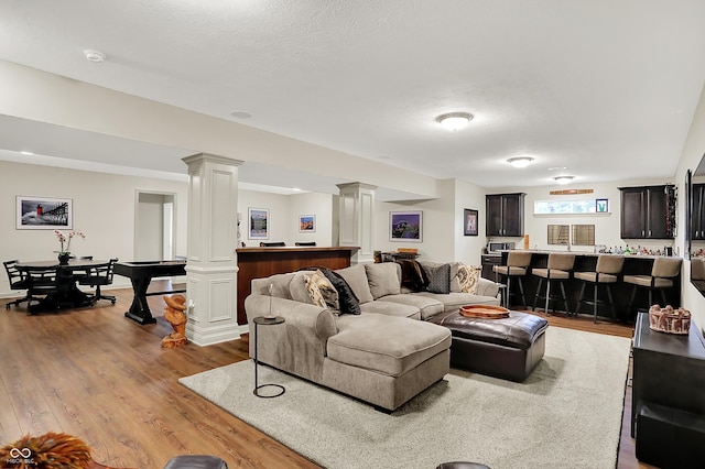15410 Mission Hills Dr, Carmel, IN 46033 - living room featuring ornate columns, wood finished floors, and bar