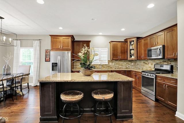 15410 Mission Hills Dr, Carmel, IN 46033 - kitchen featuring stainless steel appliances, a kitchen island, dark wood-style flooring, light stone countertops, and recessed lighting