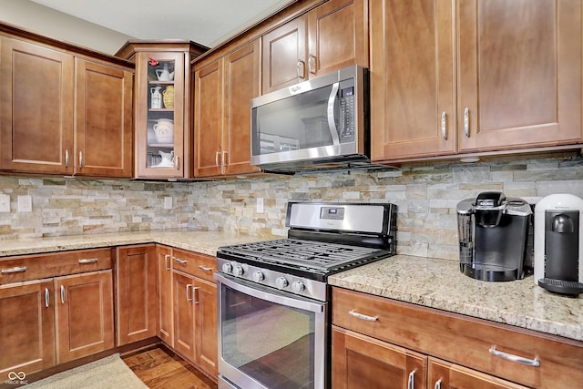 15410 Mission Hills Dr, Carmel, IN 46033 - kitchen featuring appliances with stainless steel finishes, light stone counters, and brown cabinetry