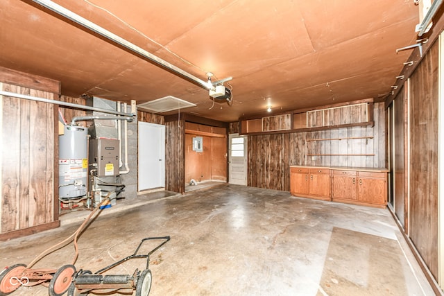 823 Rustic Rd, Anderson, IN 46013 - garage featuring water heater, wood walls, a garage door opener, and heating unit