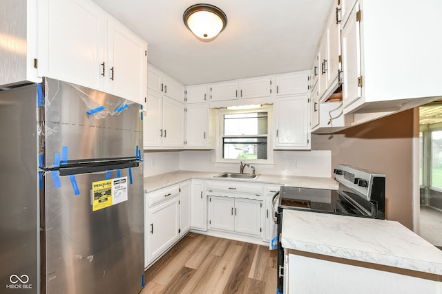 823 Rustic Rd, Anderson, IN 46013 - kitchen with appliances with stainless steel finishes, white cabinetry, light countertops, and light wood-style floors