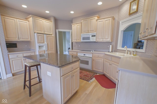 1870 Broadleaf Ct Unit 10, Greenwood, IN 46143 - kitchen with white appliances, light wood finished floors, a kitchen island, a breakfast bar area, and arched walkways