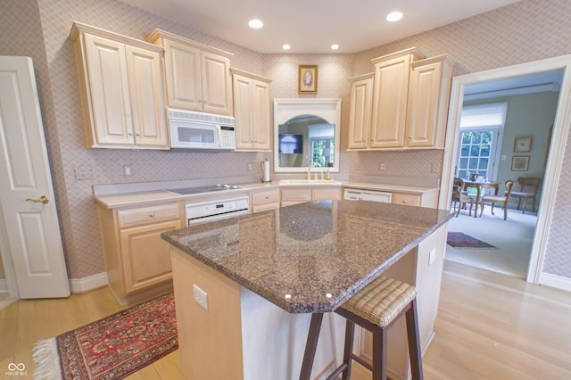 1870 Broadleaf Ct Unit 10, Greenwood, IN 46143 - kitchen featuring white appliances, wallpapered walls, light wood-style floors, healthy amount of natural light, and a center island