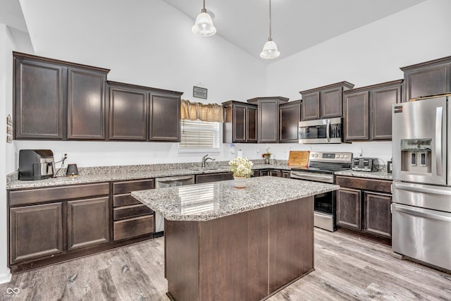 1181 S Aberdeen Dr, Franklin, IN 46131 - kitchen featuring appliances with stainless steel finishes, high vaulted ceiling, dark brown cabinetry, a center island, and light wood-style floors