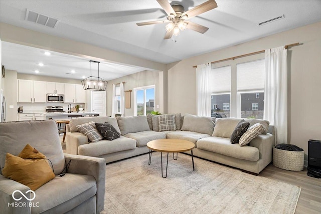 8547 Winton Pl, Pendleton, IN 46064 - living area featuring light wood finished floors, ceiling fan, a chandelier, and recessed lighting