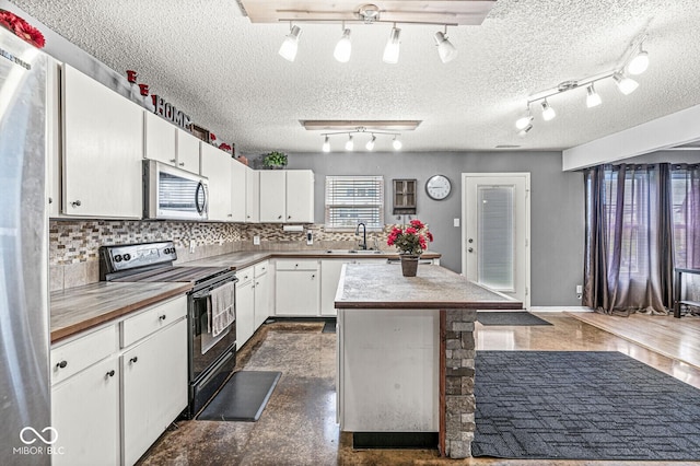 6259 Teacup Dr, Indianapolis, IN 46235 - kitchen with stainless steel appliances, track lighting, white cabinets, decorative backsplash, and a textured ceiling