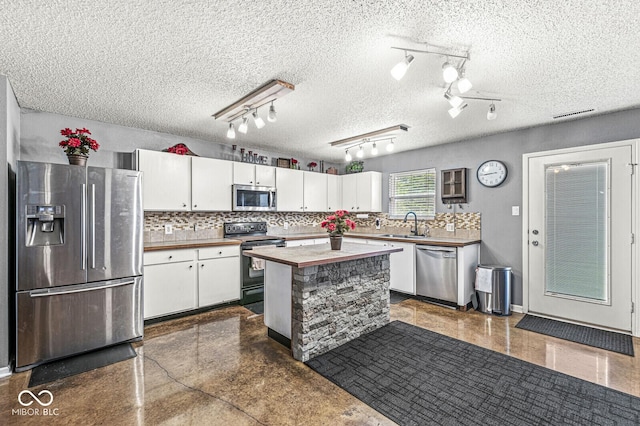 6259 Teacup Dr, Indianapolis, IN 46235 - kitchen featuring appliances with stainless steel finishes, white cabinetry, decorative backsplash, wood counters, and a textured ceiling