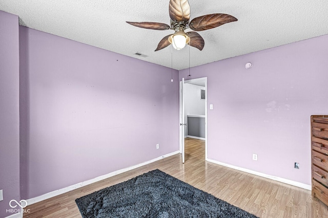 6259 Teacup Dr, Indianapolis, IN 46235 - unfurnished bedroom with wood finished floors, a textured ceiling, and ceiling fan