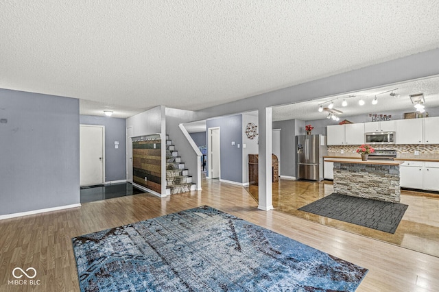 6259 Teacup Dr, Indianapolis, IN 46235 - living room with stairs, light wood-type flooring, and a textured ceiling